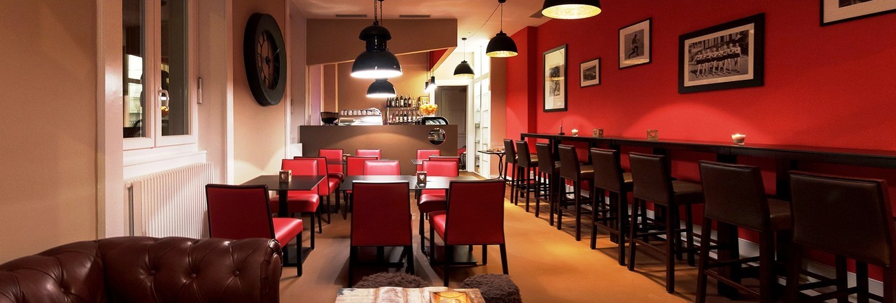 Salle de restaurant peinte par G. Pucci SA, mur rouge et plafond clair