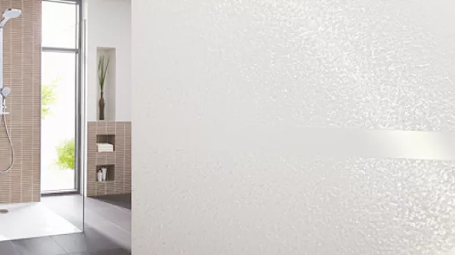 Cabine de douche carrelée et gros plan sur la texture du revêtement antidérapant GriP appliqué au sol