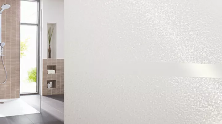 Cabine de douche carrelée et gros plan sur la texture du revêtement antidérapant GriP appliqué au sol