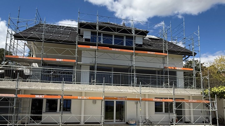 Maison individuelle entourée d'échafaudages pendant des travaux de rénovation extérieure
