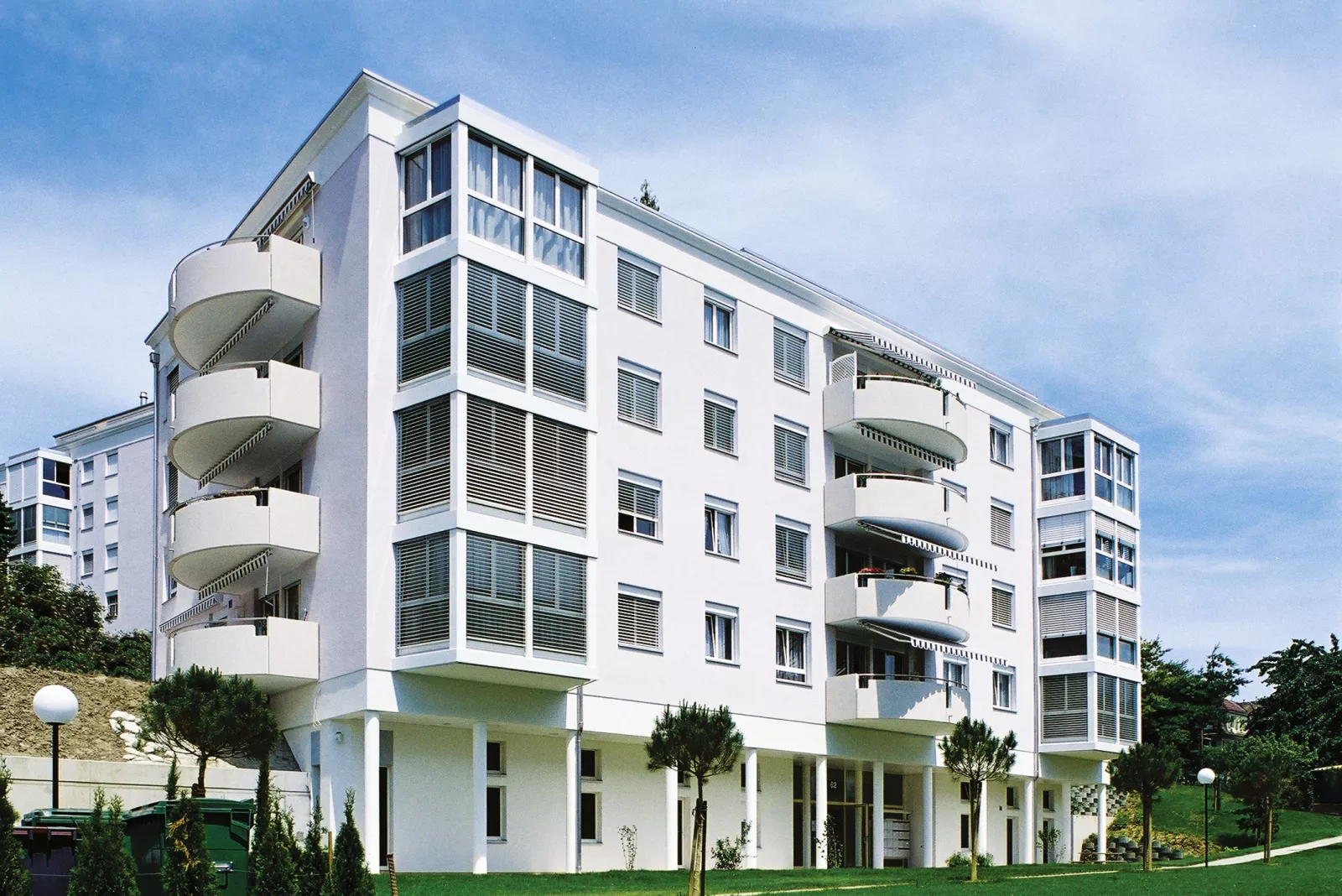 Façade blanche des Résidences des Figuiers et Rhodanie avec ses balcons arrondis