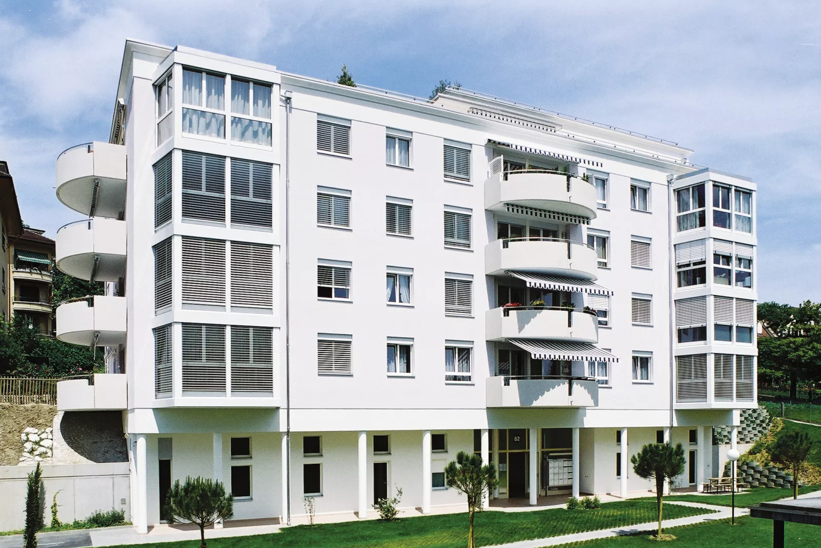 Façade blanche des Résidences Rhodanie avec ses loggias arrondies et ses stores