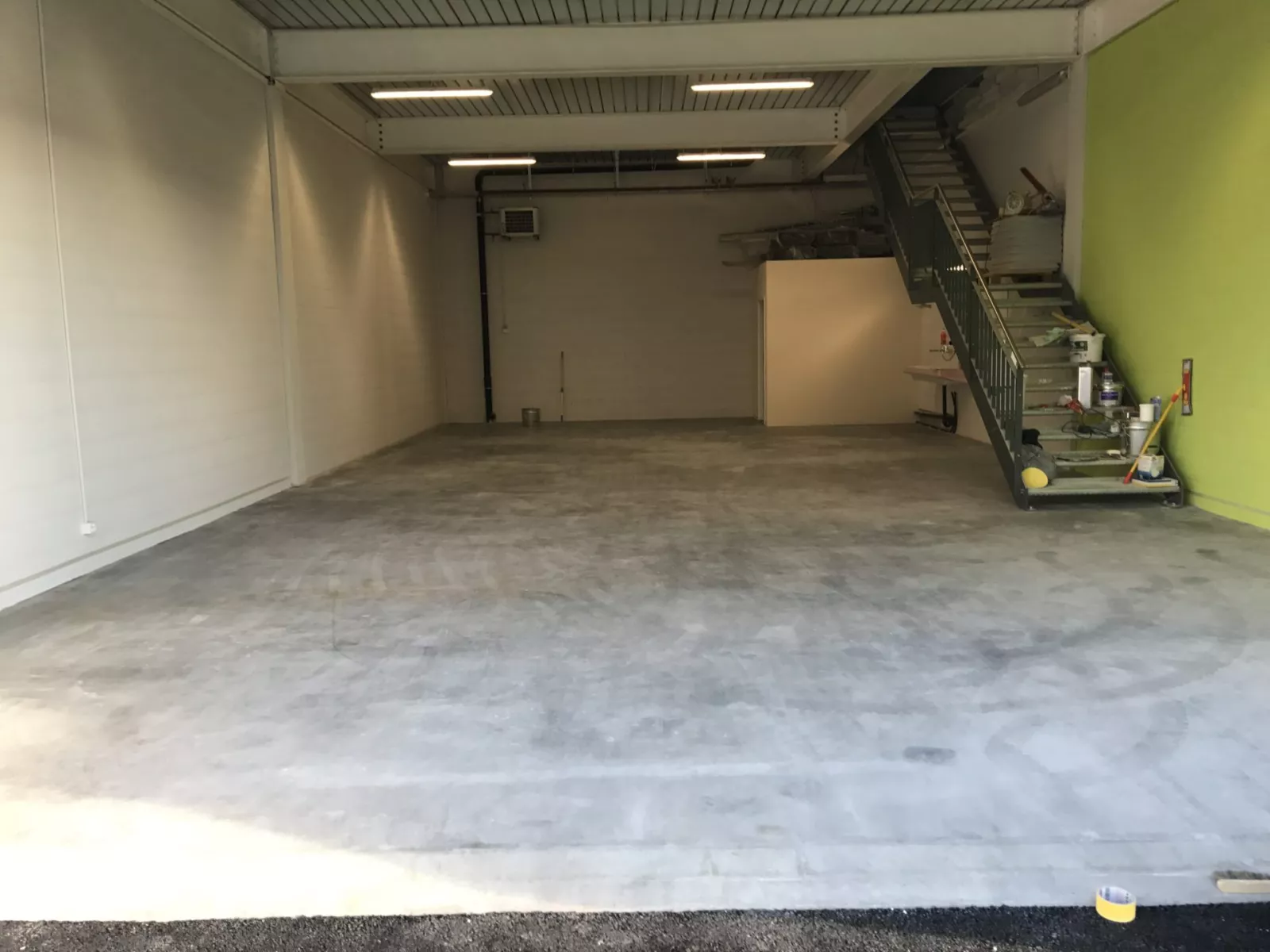 Halle de l'atelier G. Pucci SA en travaux, mur vert anis et escalier métallique