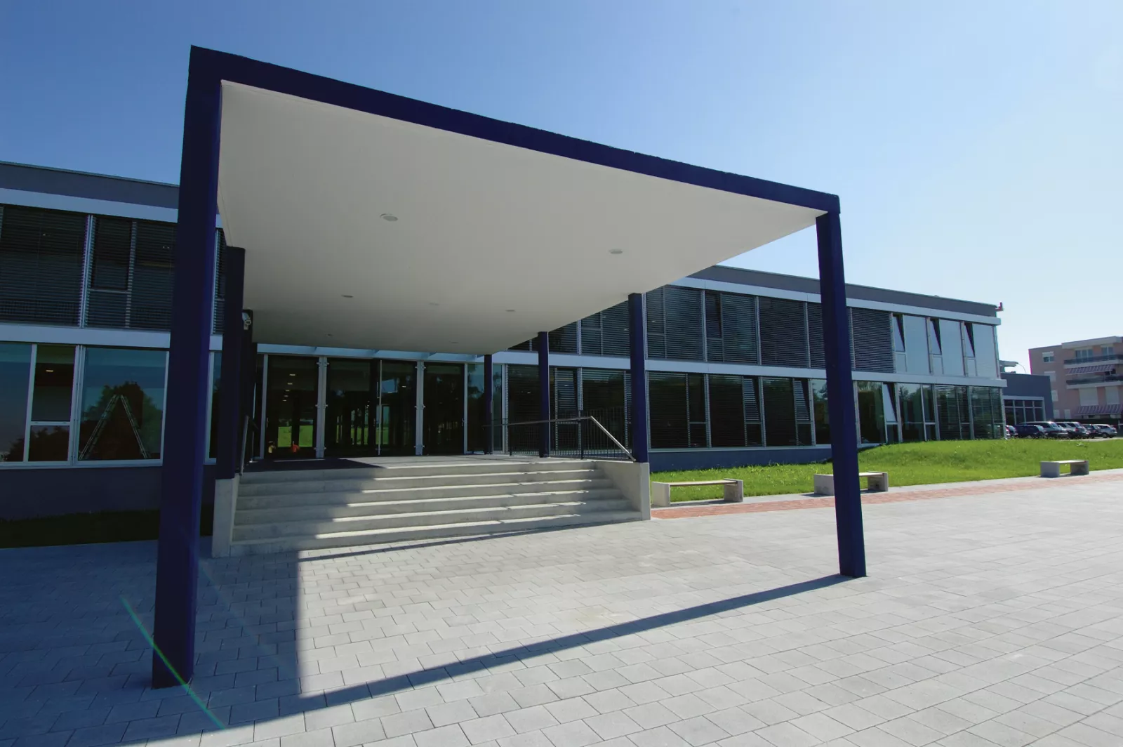 Entrée extérieure de l'International School of Lausanne encadrée d'un portique bleu foncé