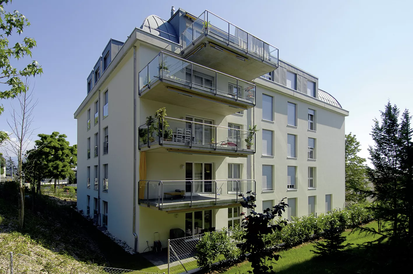 Façade claire des Balcons de Vallombreuse avec ses balcons et son attique, côté jardin