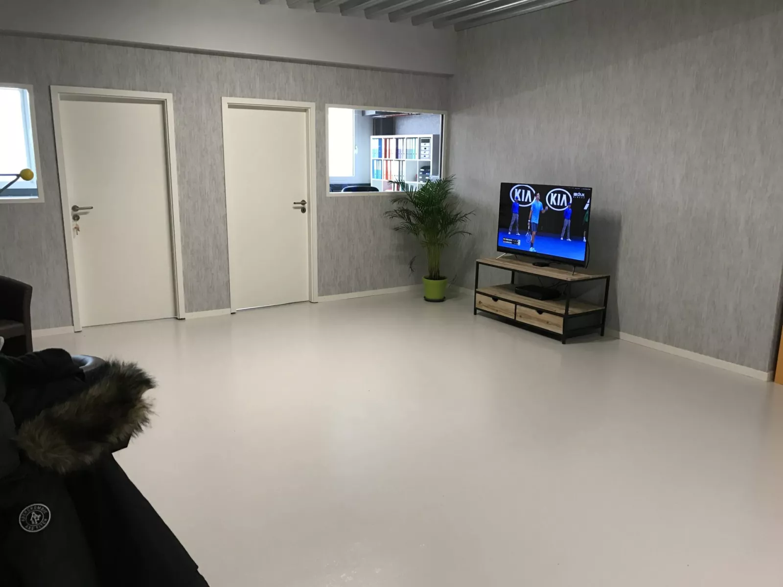 Espace de détente de l'atelier G. Pucci SA, murs à l'enduit gris et sol en résine