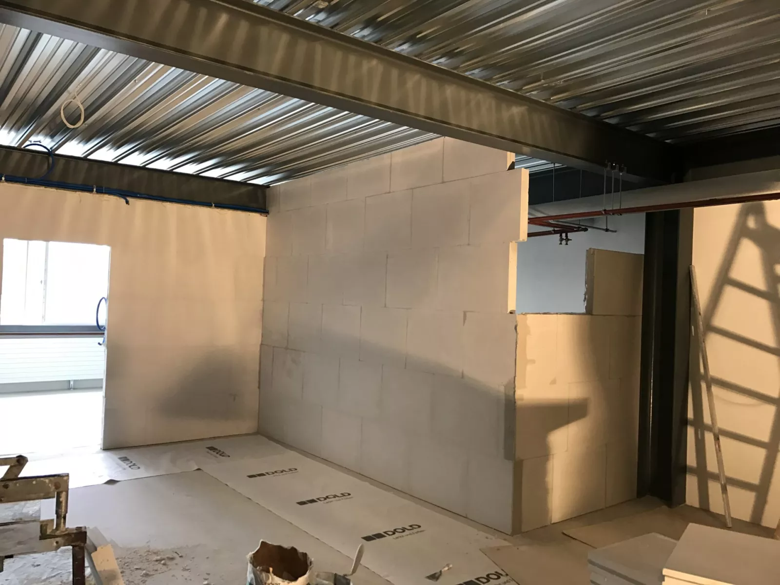 Atelier G. Pucci SA en cours d'aménagement, murs en blocs et charpente métallique apparente