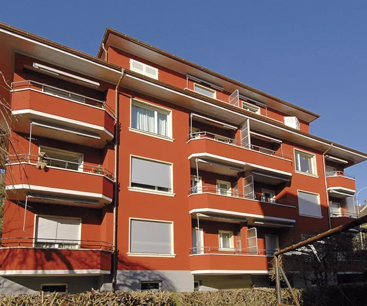 Façade rouge et balcons de l'immeuble de l'avenue Marc-Dufour